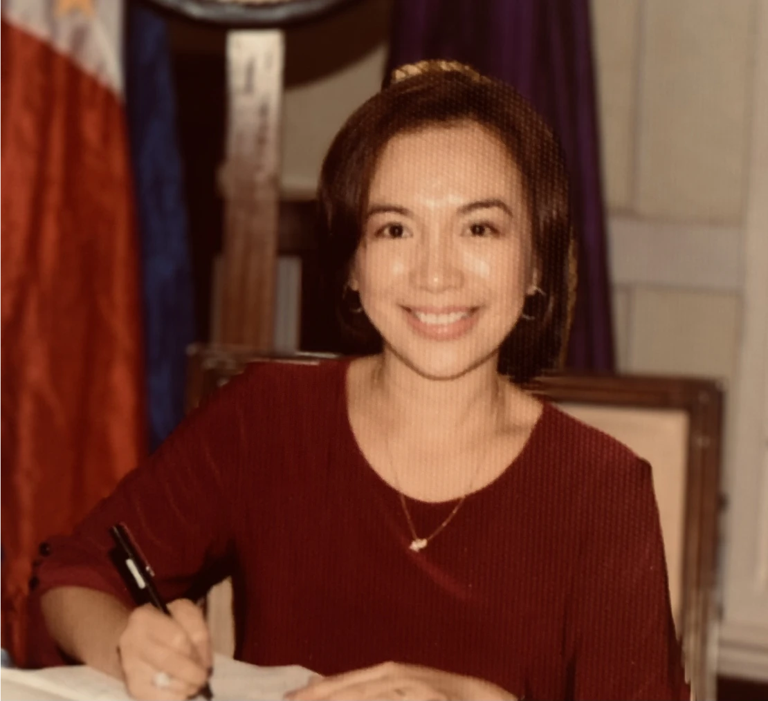 Smiling woman in red shirt signing document